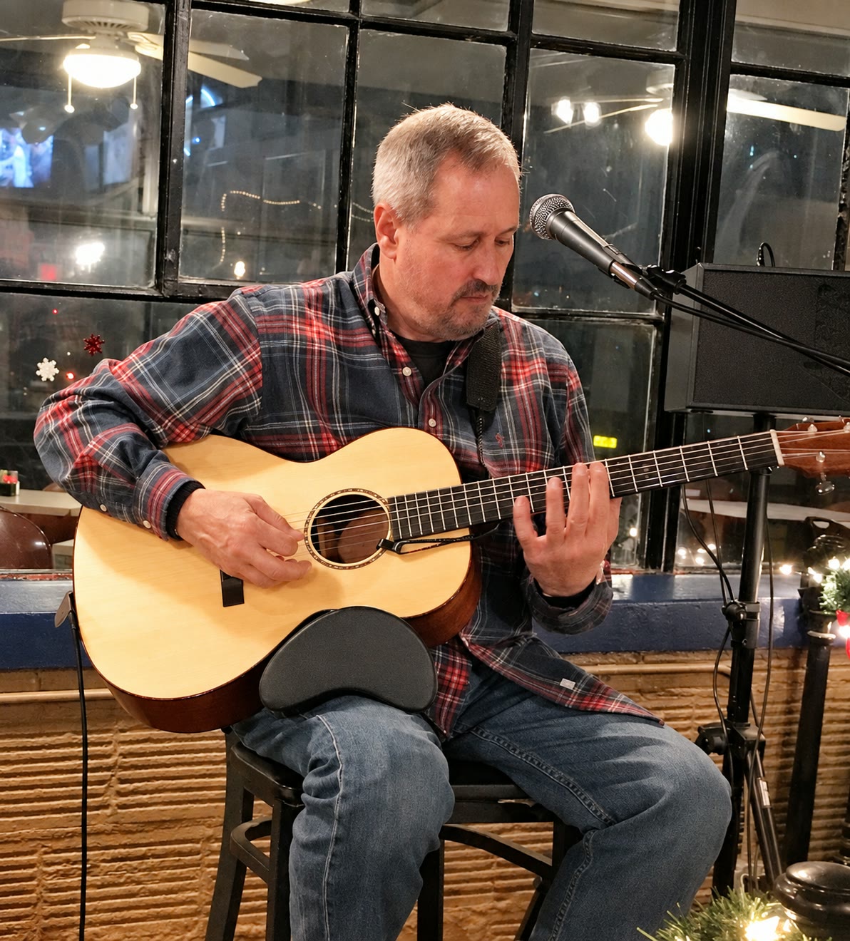 Joe Caporaso playing acoustic guitar at an intimate live performance